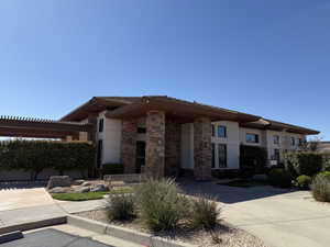 Prairie-style house with stucco siding, stone siding, and a pergola