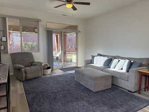 Living room featuring a ceiling fan, wood finished floors, and visible vents