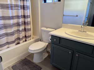 Full bath featuring vanity, toilet, shower / tub combo, and wood finished floors