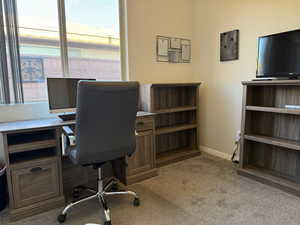 Office space with a healthy amount of sunlight, baseboards, and carpet floors