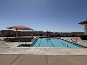 Pool with a mountain view and a patio area