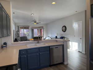 Kitchen with a sink, open floor plan, a peninsula, appliances with stainless steel finishes, and light countertops