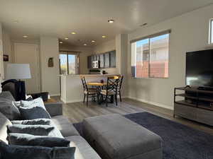 Living area with visible vents, recessed lighting, baseboards, and wood finished floors