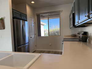 Kitchen with a sink, recessed lighting, stainless steel appliances, light countertops, and baseboards