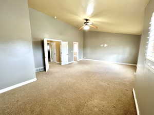 Interior space featuring lofted ceiling, baseboards, carpet floors, and ceiling fan