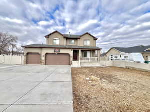 View of front of home with fence, a porch, an attached garage, stucco siding, and concrete driveway