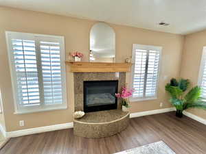 Interior details featuring a premium fireplace, wood finished floors, visible vents, and baseboards