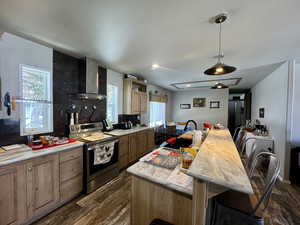 Kitchen with dark wood-type flooring, electric stove, tasteful backsplash, wall chimney exhaust hood, and light countertops