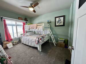 Bedroom with baseboards, carpet floors, and a ceiling fan