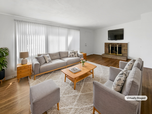 Living room featuring baseboards, wood finished floors, and a fireplace