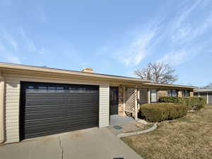 Ranch-style home with concrete driveway, brick siding, and a garage