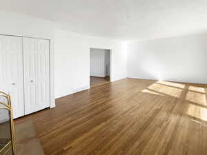 Interior space with visible vents, wood finished floors, a closet, and baseboards