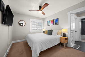 Carpeted bedroom featuring baseboards and a ceiling fan