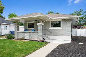 View of front of house with a gate, fence, a front lawn, and brick siding