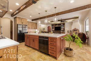 Kitchen with beam ceiling, arched walkways, stainless steel appliances, light quartz countertops, and open floor plan