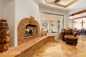 Featuring beamed ceiling, stone tile flooring, and a fireplace