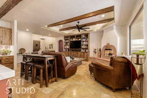 Living room featuring beamed ceiling, ceiling fan with notable chandelier, recessed lighting, arched walkways, and a textured ceiling