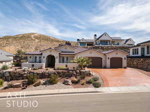 View of front facade with stucco siding, a garage, concrete driveway, and a tile roof