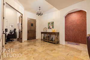 Entrance foyer featuring a notable chandelier and arched walkways