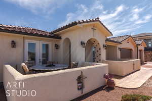 Exterior space featuring french doors, a garage, and an enclosed courtyard patio