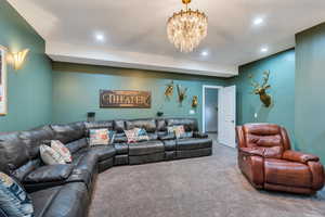 Living room featuring recessed lighting, carpet flooring, and an inviting chandelier