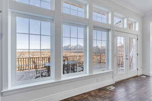 Doorway featuring visible vents, crown molding, baseboards, a mountain view, and dark wood-style flooring