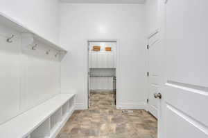 Mudroom with visible vents, stone finish flooring, and baseboards