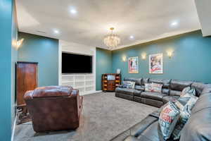 Carpeted living room with recessed lighting, a textured ceiling, a chandelier, and visible vents