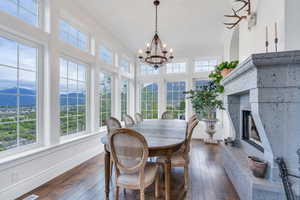 Sunroom featuring ornamental molding, wood-type flooring, a mountain view, and a notable chandelier