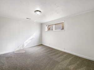 Unfurnished room with ornamental molding, carpet, visible vents, and baseboards