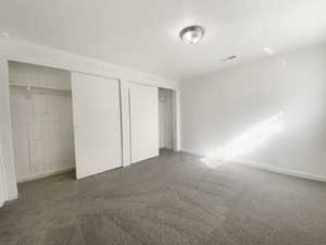 Unfurnished bedroom with visible vents, a closet, and carpet flooring