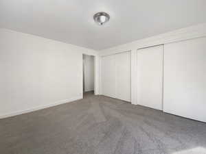 Unfurnished bedroom featuring multiple closets and carpet floors