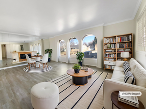 Living room with baseboards, wood finished floors, and ornamental molding