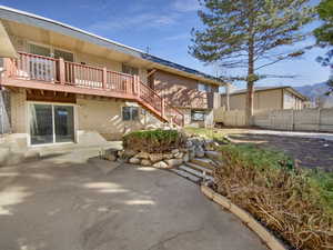 Rear view of house with a patio area, stairway, fence, and brick siding