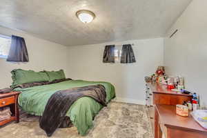 Bedroom with baseboards and a textured ceiling