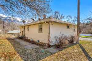 View of home's exterior featuring a mountain view, stucco siding, entry steps, and a chimney