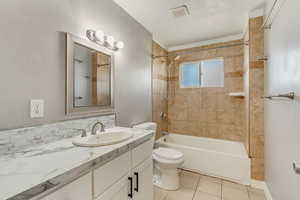 Full bath with visible vents, washtub / shower combination, toilet, tile patterned floors, and vanity