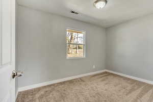 Spare room with carpet flooring, baseboards, and visible vents