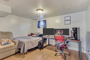 Bedroom with a textured ceiling and wood finished floors