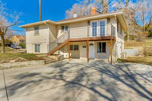 Back of property with stairs, french doors, a chimney, and stucco siding