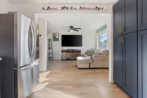 Kitchen featuring light wood-style flooring, freestanding refrigerator, and ceiling fan