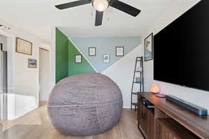 Living area featuring ceiling fan, baseboards, and wood finished floors