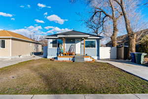 Bungalow featuring a front lawn and a gate