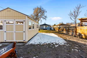 View of yard featuring an outdoor structure and fence