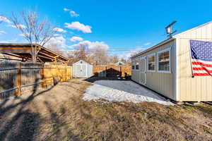 View of yard featuring an outbuilding, a fenced backyard, and a shed