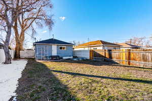 Rear view of house featuring a lawn and a fenced backyard