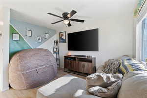 Living area featuring ceiling fan, baseboards, and wood finished floors