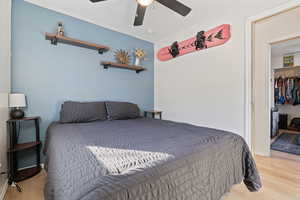 Bedroom with a ceiling fan, baseboards, and light wood finished floors