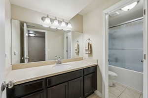 Full bathroom with tile patterned flooring, visible vents, toilet, combined bath / shower with glass door, and vanity