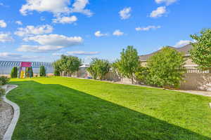 View of yard featuring a playground and a fenced backyard